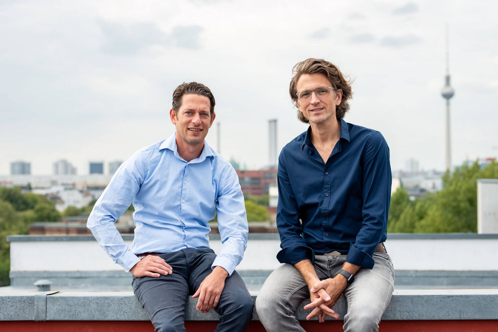 Geschäftsführer Ben Künkler und Eric Ovaska sitzen auf dem Dach der VALID Digitalagentur über Berlin.